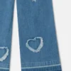 Jeans in denim elasticizzato con toppa a forma di cuore con frange Jeans in denim elasticizzato con toppa a forma di cuore con frange